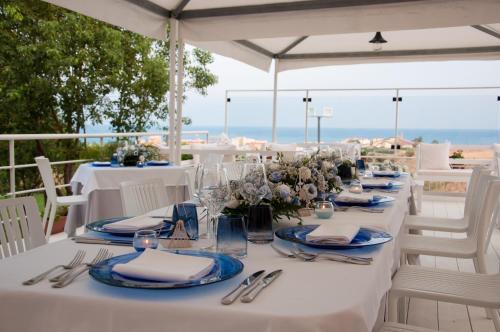 a white table with blue plates and napkins on it at Grand Hotel Paradiso in Catanzaro Lido