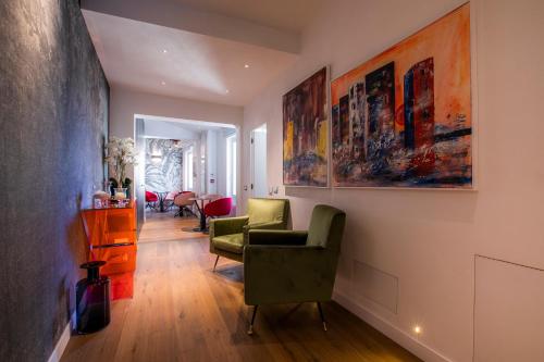 a living room with a chair and paintings on the wall at Residenza Benizzi rooms in the heart of Florence in Florence