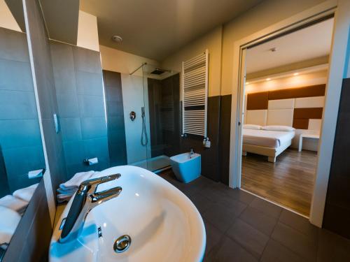 a bathroom with a sink and a bedroom at Hotel Sirio - Sure Hotel Collection by Best Western in Medolago