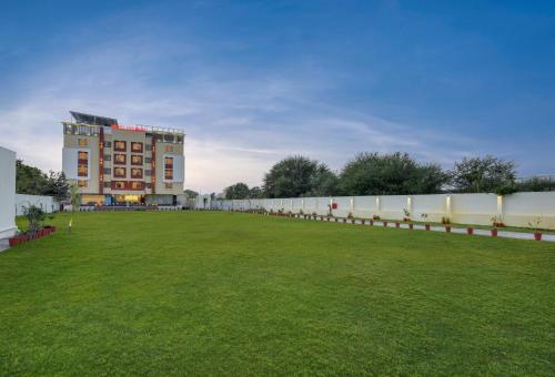 a large field in front of a large building at Hotel khumani By Hills N Dunes in Udaipur