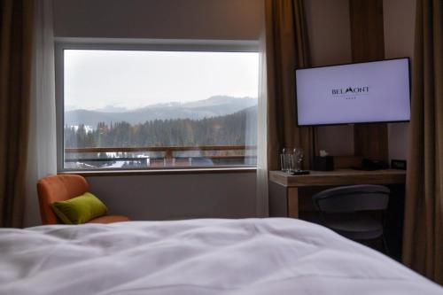 a bedroom with a bed and a window with a view at Hotel Belmont & Spa in Sinaia