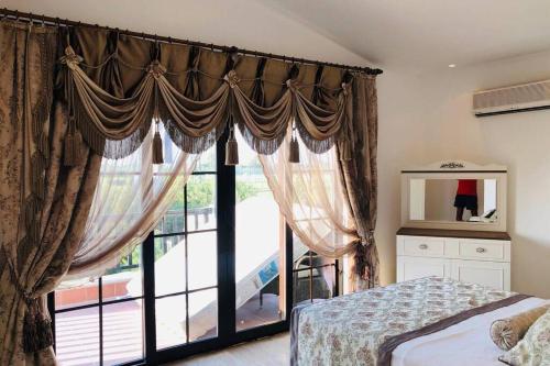 - une chambre avec un lit et une grande fenêtre dans l'établissement Fun&Sun Luxury River Villa With Amazing Landscape, à Belek