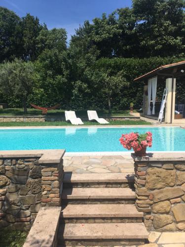 a swimming pool with stairs next to a stone wall at Podere Belvedere - Villa with private swimming-pool in Carmignano