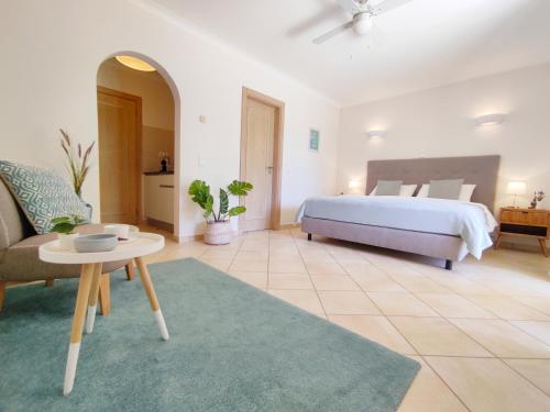 a bedroom with a bed and a couch and a table at Casa Canavial in Luz