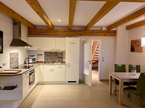 eine Küche mit weißen Schränken und einer Holzdecke in der Unterkunft Ferienwohnungen Weitblick & Am Speicher in Wiek auf Rügen 