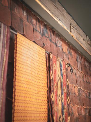 a brick wall with a window and a rug at Hungry Grape Guests in Erdőbénye