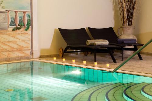 a pool with a chair and candles in a room at Hotel Casa Di Meglio in Ischia