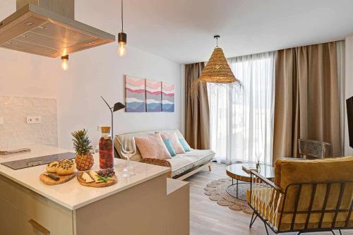 sala de estar con cocina y sala de estar con sofá en Jable suites apartamentos de lujo en el centro, en Corralejo