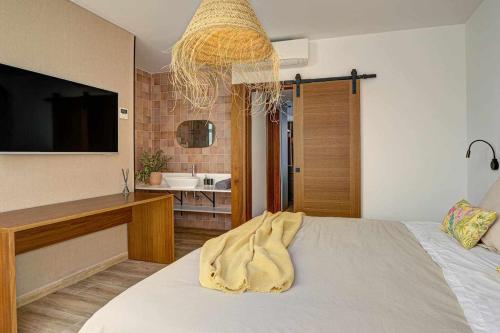 コラレホにあるJable suites apartamentos de lujo en el centroのベッドルーム(ベッド1台、テレビ、バスルーム付)