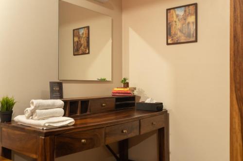 a bathroom with a wooden dresser and a mirror at Myna Villa in Lonavala