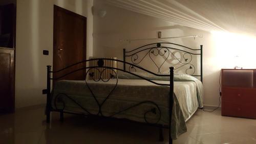 サンタルチアにあるB & B La Mansardaのベッドルーム1室(錬鉄製のフレーム付きベッド1台付)