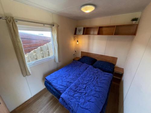 - un petit lit dans une petite chambre avec fenêtre dans l'établissement Duindoorn 45, à IJmuiden