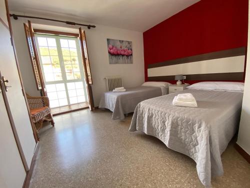 a bedroom with two beds and a red wall at El Puente in Boltaña
