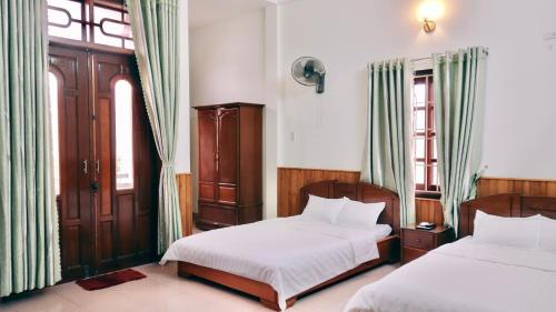 Llit o llits en una habitació de Hai Huong Hotel