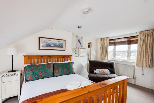 a bedroom with a bed and a chair at Cosy Victorian Terrace house in Jericho in Oxford