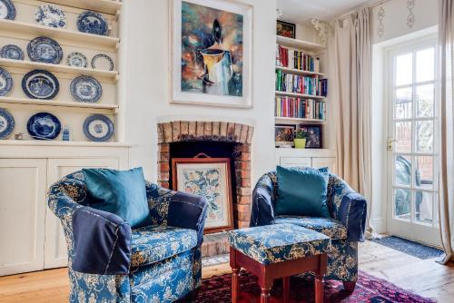 a living room with two chairs and a fireplace at Cosy Victorian Terrace house in Jericho in Oxford