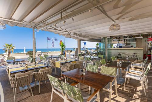 a restaurant on the beach with tables and chairs at Princess Irini Sea Front ApartHotel in Rethymno Town