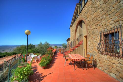 a patio with tables and chairs on a building at Hotel Residence Villa Rioddi in Volterra