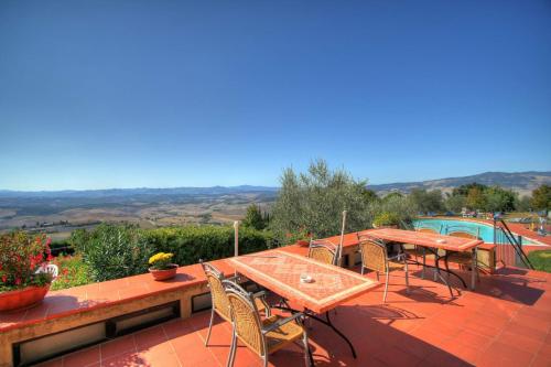 a patio with a table and chairs and a pool at Hotel Residence Villa Rioddi in Volterra