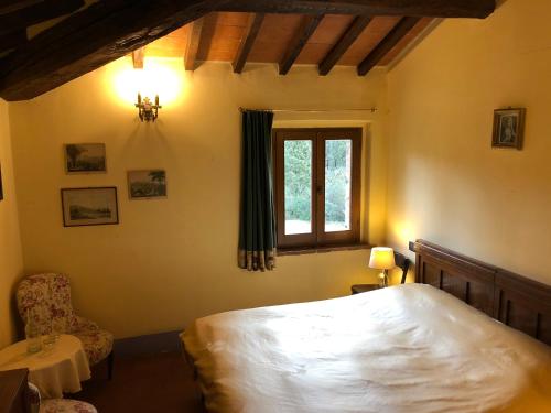 a bedroom with a bed and a window and a chair at Al Giardino Degli Etruschi in Chiusi