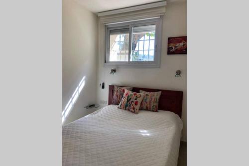 a small bedroom with a bed and a window at דירת נופש - עין כרם in ‘En Kerem