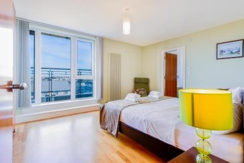 a bedroom with a bed and a large window at Britannia Penthouse in Edinburgh