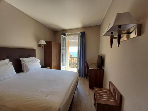 a bedroom with a large bed and a window at Hotel Capitole in Beausoleil