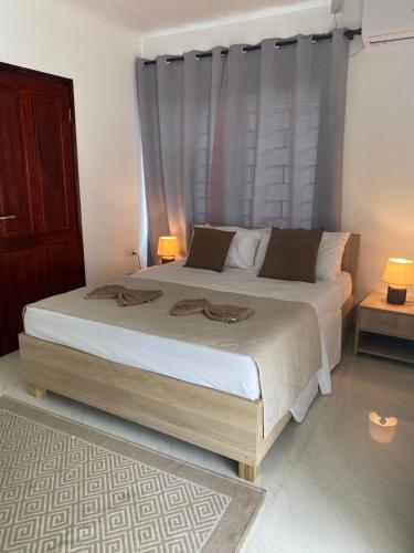 a bedroom with a large bed with two lamps at Hotel Plein Soleil in Grand Anse