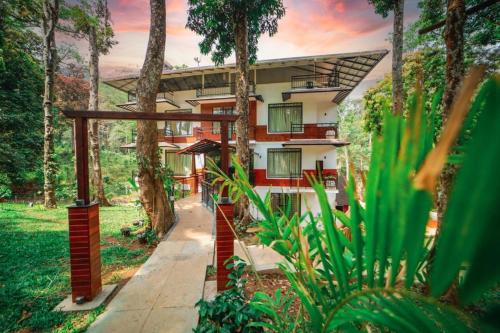 a building in the middle of a forest with trees at VANYA by Citrine in Nelliyampathy