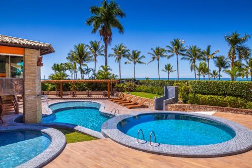 ポルト・セグロにあるQuinta do Sol Praia Hotelのプール付きの裏庭、ヤシの木が茂るパティオ