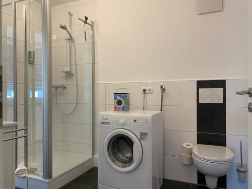 a bathroom with a washing machine and a toilet at Time Out Apartments in Herzogenaurach