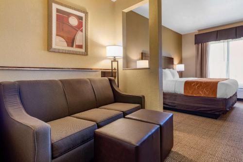 a hotel room with a couch and a bed at Comfort Suites Airport South in Montgomery