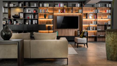 a living room with a couch and a television at Coast Hotel & Spa - Adults Only Aperto tutto l'anno in Milano Marittima