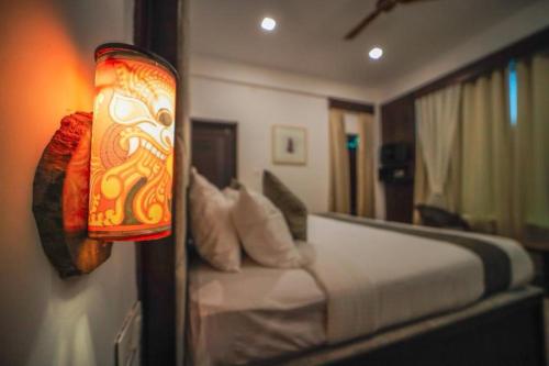 a bedroom with a bed and a light on the wall at VANYA by Citrine in Nelliyampathy