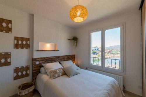 a bedroom with a large bed with a large window at CHARMAND T2 AVEC VUE SUR LAC, TERRASSE TOUT EQUIPE in Gap