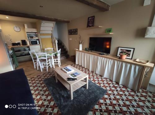 un salon avec une table et une cuisine dans l'établissement La petite maison dans la bastide, à Carcassonne