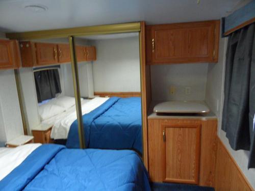 a small bedroom with two beds and a mirror at Pahrump RV Park & Lodging in Pahrump