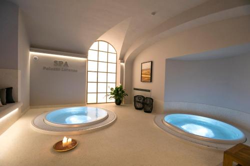 佛羅倫斯的住宿－Palazzo Lorenzo Hotel Boutique & Spa，带窗户的浴室内的2个大浴缸