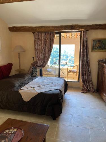 a bedroom with a bed and a large window at Rose in Bonnieux