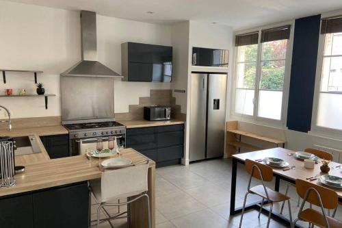 a kitchen with a stove and a table with chairs at Maison Saint Louis in Poitiers