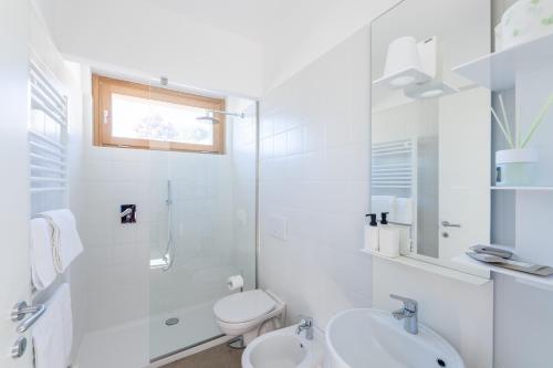 a white bathroom with a toilet and a sink at Agriturismo Umbrian Sunrise in Cannara