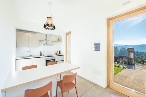 eine Küche mit einer weißen Theke und einem großen Fenster in der Unterkunft Agriturismo Umbrian Sunrise in Cannara