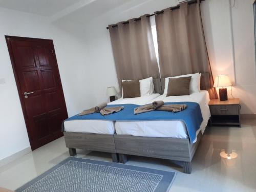a bedroom with a bed with towels on it at Hotel Plein Soleil in Grand Anse