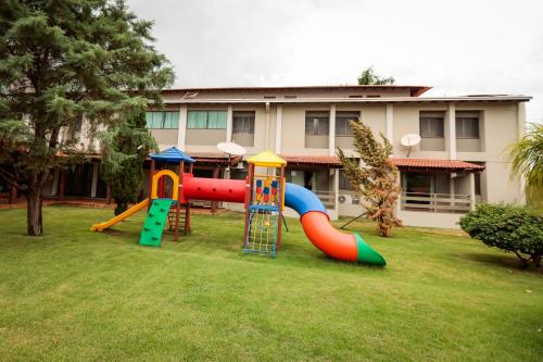 a playground with a slide in a yard at Hotel Pousada da Serra in Maracaju