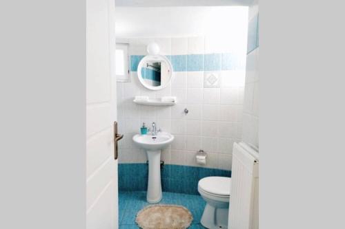 a bathroom with a sink and a toilet and a mirror at Casetta Annaise Mykonos-Myconian House for two in Mýkonos City
