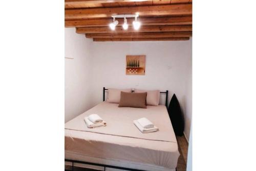 een slaapkamer met een bed in een kamer met houten plafonds bij Casetta Annaise Mykonos-Myconian House for two in Mykonos-stad
