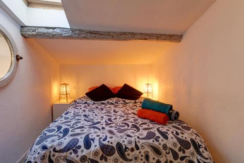 une chambre avec un grand lit avec des oreillers colorés dans l'établissement Duplex des 13 Cantons, à Marseille