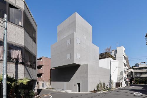 a tall concrete building on the side of a street at 2269AZAVU in Tokyo