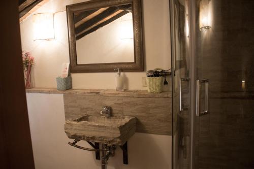 a bathroom with a stone sink and a mirror at La Mora Exclusive in Moricone