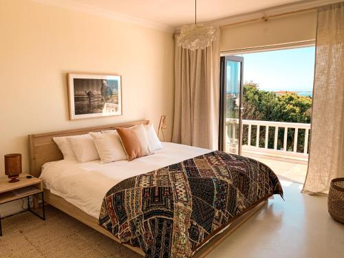 a bedroom with a bed and a large window at Luxury Home with Stunning Views and Solar Power in St Francis Bay